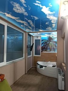 a bathroom with a bath tub and a ceiling with clouds at Apartments Zlatko in Soko Banja
