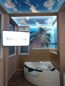 a bathroom with a bath tub and a palm tree mural at Apartments Zlatko in Soko Banja