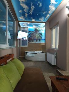 a bedroom with a bathroom with a tub and a tv at Apartments Zlatko in Soko Banja