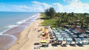 - une vue sur une plage avec des parasols et l'océan dans l'établissement Pousada Bromélias - Suítes e Aptos, à Nova Viçosa