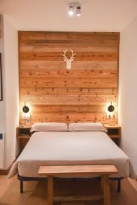 a bedroom with a bed with a wooden headboard at Envalira Vacances - Woody in Pas de la Casa