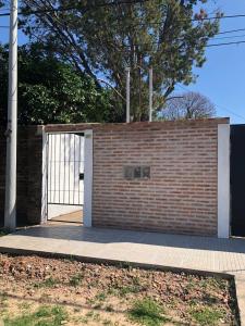 una pared de ladrillo con puerta y acera en Rugidor Alojamientos en Corrientes