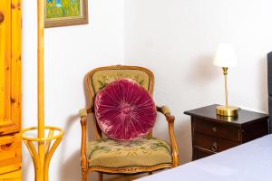 einen Stuhl mit einem rosa Kissen neben einem Tisch in der Unterkunft Villa Daringer in Mayrhofen