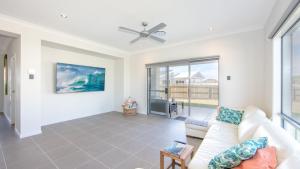 a living room with a couch and a ceiling fan at Surf and Dunes in Yamba