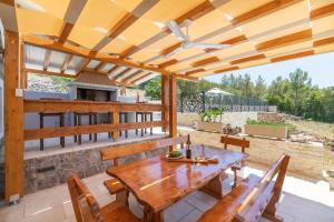 un patio al aire libre con mesa de madera y sillas en Prapatna, en Smokvica