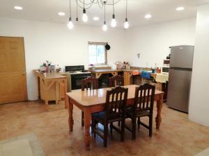 cocina con mesa, sillas y nevera en Hostal Font´s en Areponapuchi