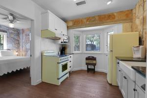 a kitchen with a yellow stove and a bed at Milk Bath Springs Cottage in Dripping Springs