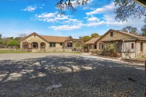 a house with a driveway in front of it at Milk Bath Springs Cottage in Dripping Springs