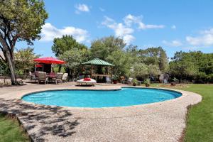 a swimming pool in a yard with a gazebo at Painted Paradise Guest Suite in New Braunfels