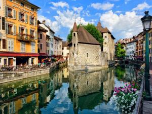 a canal in the middle of a city with buildings at Studio 2022 terrasse parking 5 min d'Annecy in Poisy