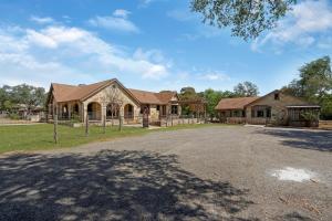 a large house with a driveway in front of it at Milk Bath Springs House in Dripping Springs