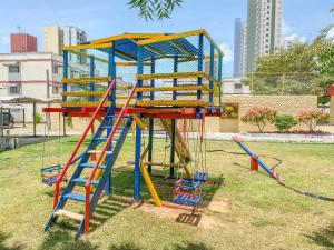 a playground with a colorful slide in a park at Hospede-se com conforto em Capim Macio in Natal