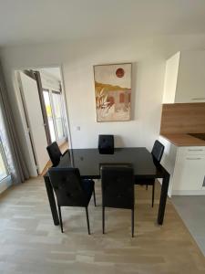 uma sala de jantar com uma mesa preta e cadeiras em Luxury appartement 5 Asnières Paris em Asnières-sur-Seine