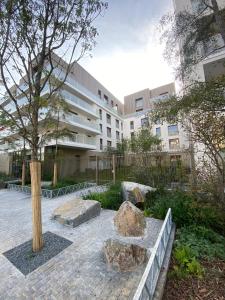 塞納河畔阿涅勒的住宿－Luxury appartement 5 Asnières Paris，庭院中一座有树和岩石的建筑