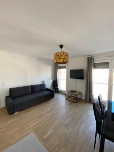 a living room with a couch and a tv at Luxury appartement 5 Asnières Paris in Asnières-sur-Seine