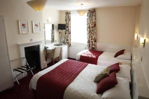 ロンドンにあるサネット ホテルのベッド2台とデスクが備わるホテルルームです。