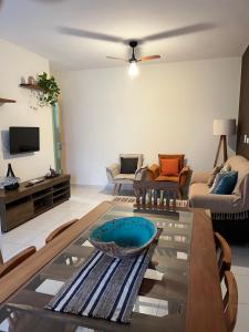 een woonkamer met een tafel en een bank bij Apt 2 suites com ar condicionado e piscina Ubatuba in Ubatuba