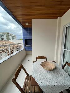 een tafel en stoelen op een balkon met uitzicht bij Apt 2 suites com ar condicionado e piscina Ubatuba in Ubatuba