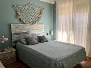 een slaapkamer met een bed met een hangende mand aan de muur bij Adosado para familias al lado de la playa, con piscina in Castellón de la Plana