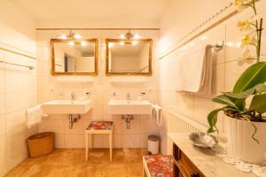 ein Badezimmer mit zwei Waschbecken und zwei Spiegeln in der Unterkunft Villa Daringer in Mayrhofen