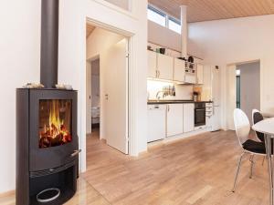 6 person holiday home in Bogense في بوجنسي: مطبخ وغرفة معيشة مع موقد