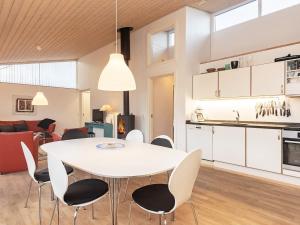 6 person holiday home in Bogense في بوجنسي: غرفة طعام ومطبخ مع طاولة وكراسي بيضاء