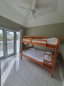 two bunk beds in a room with a window at Townhouse by The Bay, Little Bay Country Club ,Negril in Orange Bay