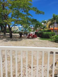 una cerca blanca frente a un patio con un árbol en Townhouse by The Bay, Little Bay Country Club ,Negril, en Orange Bay