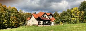 a house with an orange roof on a green hill at Dobra1 in Ściegny