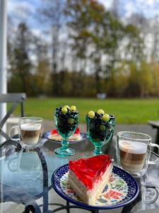 un tavolo con un pezzo di torta e due bicchieri di caffè di Dobra1 a Ściegny