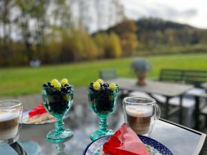un tavolo con tre bicchieri di vino e del cibo di Dobra1 a Ściegny