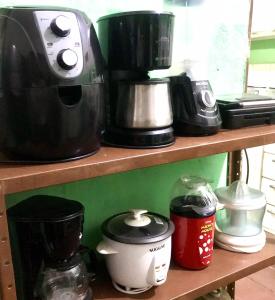a shelf with coffee makers and appliances on it at Pousada Cisne Branco in Natal