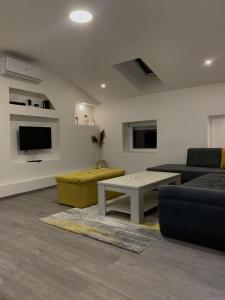 een woonkamer met een bank en een tafel bij Apartment Grey in Sarajevo