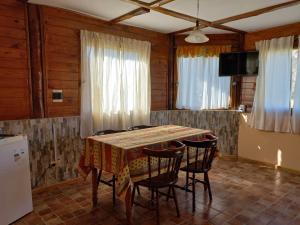 エル・チャルテンにあるComplejo Las Marasのテーブルと椅子とテレビのあるダイニングルーム