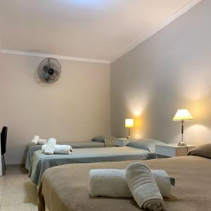 a hotel room with three beds and a fan at Hotel Di Sorrento in Mar del Plata
