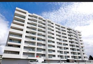 un grand bâtiment blanc avec des voitures garées devant lui dans l'établissement DiVine Luxury Apartment Blue, à Zadar