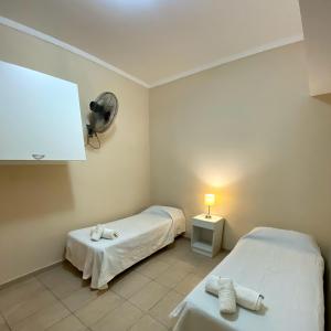 a small room with two beds and a fan at Hotel Di Sorrento in Mar del Plata