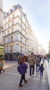 a group of people walking down a city street at La Suite à Chatelet in Paris