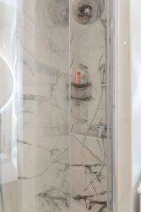 a bathroom with a shower with marble walls at La Suite à Chatelet in Paris