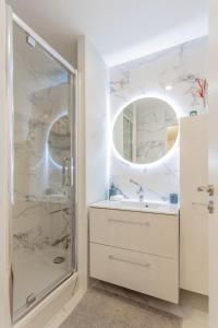 a white bathroom with a shower and a sink at La Suite à Chatelet in Paris