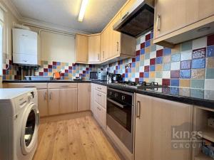 a kitchen with a stove top oven next to a dishwasher at A cosy 1 bedroom apartment in Enfield