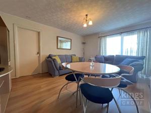 een woonkamer met een tafel en een bank bij A cosy 1 bedroom apartment in Enfield