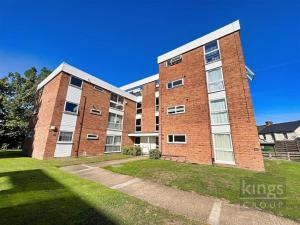 a large brick building with a grassy yard in front of it at A cosy 1 bedroom apartment in Enfield