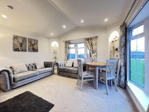 a living room with a couch and a table and chairs at Stewarts Resort Lodge 4 in St. Andrews