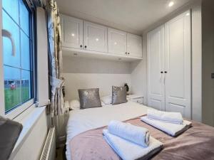 a bedroom with a bed with two towels on it at Stewarts Resort Lodge 4 in St Andrews