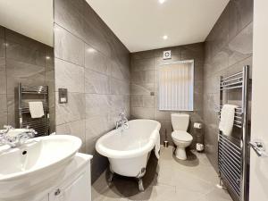 a bathroom with a sink and a tub and a toilet at Stewarts Resort Lodge 4 in St. Andrews +23 photos