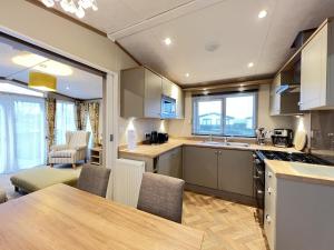 a kitchen and dining room with a table and chairs at Stewarts Resort Lodge 14 in St. Andrews