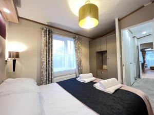 sypialnia z dużym łóżkiem z dwoma ręcznikami w obiekcie Stewarts Resort Lodge 14 w mieście St Andrews