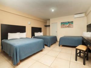 ein Hotelzimmer mit zwei Betten und einem Waschbecken in der Unterkunft Hotel Puerto Inn in Veracruz