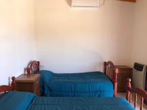1 Schlafzimmer mit 2 Einzelbetten und einem Schreibtisch in der Unterkunft Parque Las Naciones in San Luis